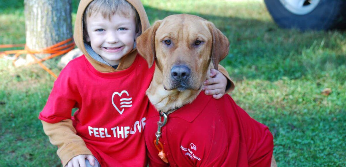 Image of a small boy and a dog both wearing Lennox shirts
