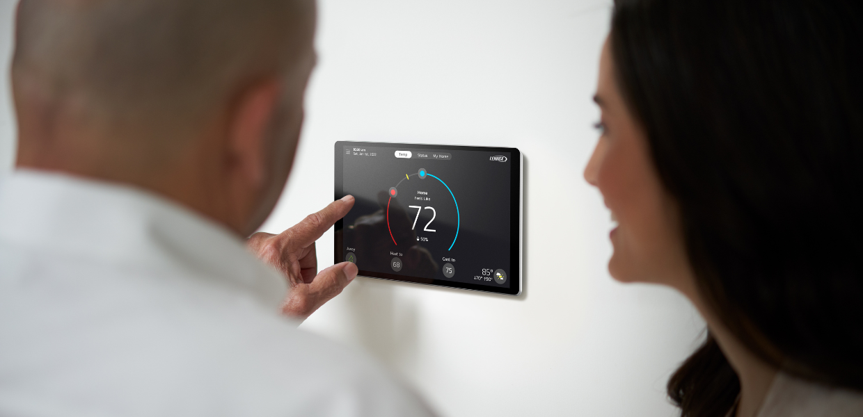 Image of a Lennox dealer with a homeowner and smart thermostat