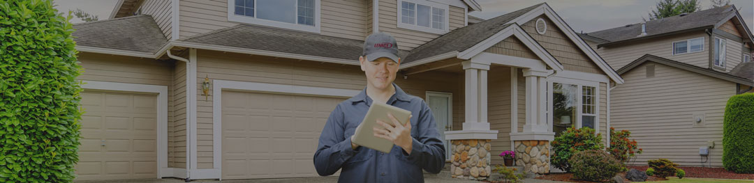 Image of a Lennox technician outside of a house on his tablet.